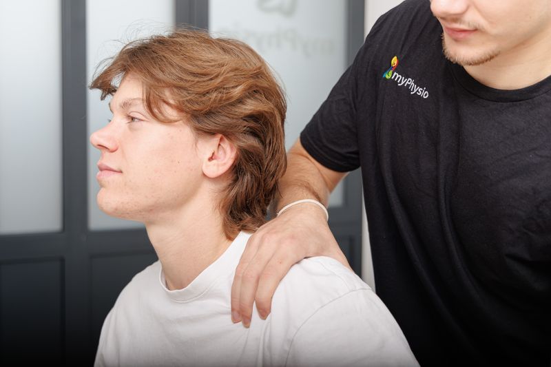 Therapeut legt einem Patienten die Hand auf die Schulter.