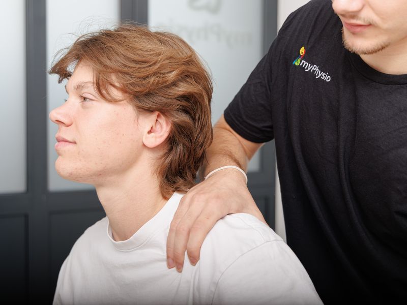 Therapeut legt einem Patienten die Hand auf die Schulter.
